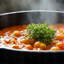 Plato humeante de potaje de garbanzos y verduras de invierno.